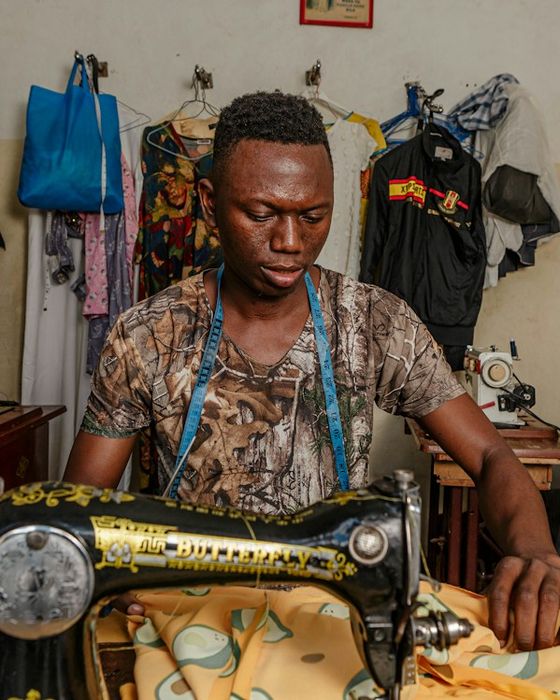 A tailor at work on his sewing machine in his shop